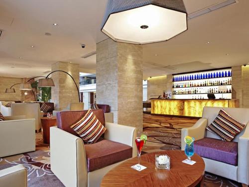 a lobby with a table and chairs and a bar at Pullman Xiamen Powerlong in Xiamen