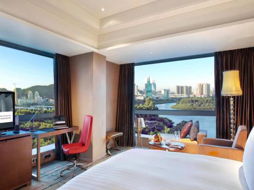 a hotel room with a bed and a large window at Pullman Xiamen Powerlong in Xiamen
