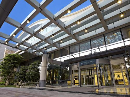 an office building with a glass ceiling and a glass entrance at Pullman Xiamen Powerlong in Xiamen