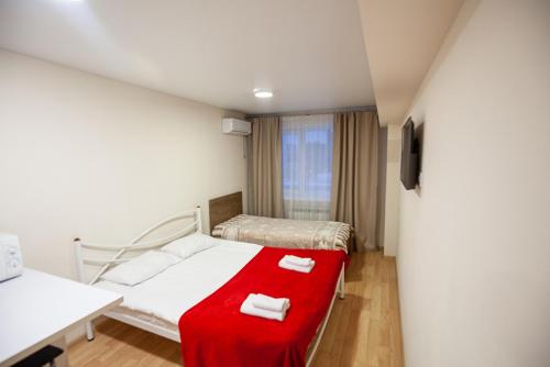 una camera da letto con un letto con una coperta rossa sopra di New quiet place in Kiev a Kiev