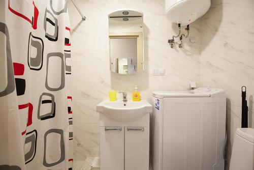 a white bathroom with a sink and a mirror at New quiet place in Kiev in Kyiv