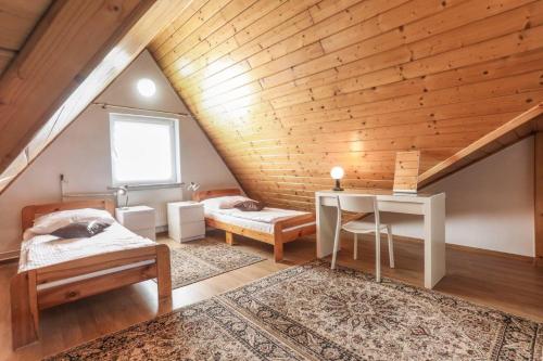a bedroom with a bed and a desk in a attic at Hotel Milena in Milówka