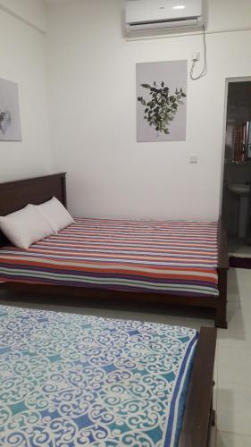 a bedroom with a bed with a striped blanket at Surf reef beach in Trincomalee