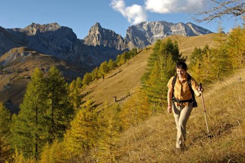 a woman walking on a trail in the mountains at Hôtel Les Bains d'Ovronnaz in Ovronnaz