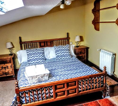 1 dormitorio con 1 cama grande de madera y 2 mesas en Posada Paz, en Hinojedo