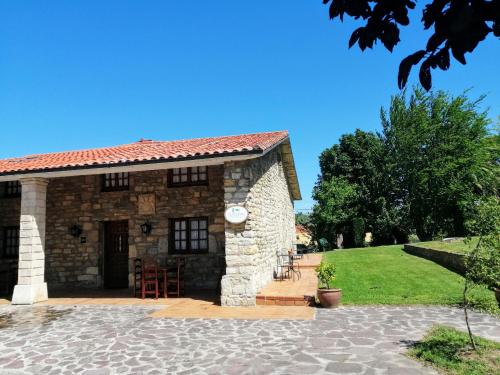 a stone house with a porch and a patio at Posada Paz in Hinojedo