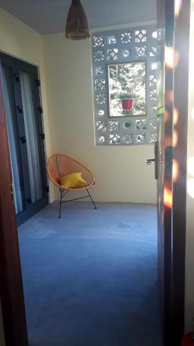 a room with a chair and a window at Pink Tulip Hoi An in Hoi An