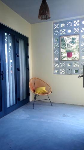 a chair sitting in a room next to a window at Pink Tulip Hoi An in Hoi An