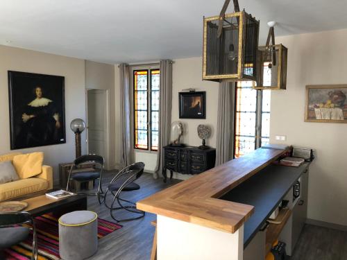 a living room with a kitchen with a counter top at Le 39 Bis in Rémalard