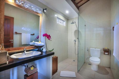a bathroom with a toilet and a sink and a shower at Nata Ubud in Ubud