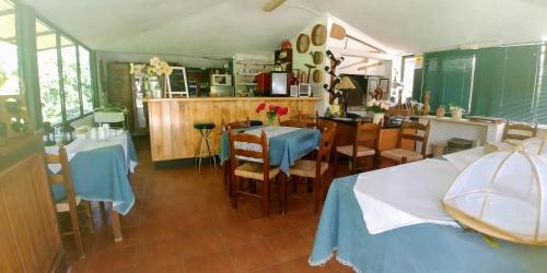 una cucina e una sala da pranzo con due tavoli e sedie di La Piana degli Ulivi a Rossano