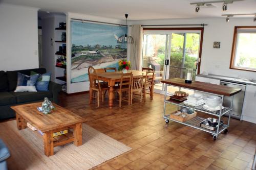 ein Wohnzimmer mit einem Tisch und einem Sofa in der Unterkunft A2@Port Willy in Port Willunga