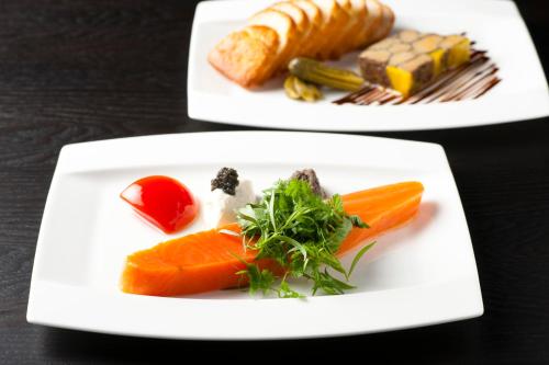 two white plates with different types of food on them at The Gate Hotel Kaminarimon by Hulic in Tokyo