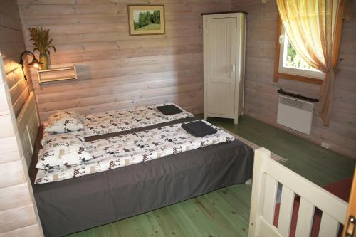 a bedroom with a bed in a wooden room at Viesu mājas Briedīši in Raiskums