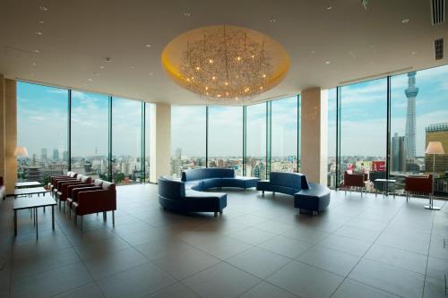 a lobby with couches and chairs and a chandelier at The Gate Hotel Kaminarimon by Hulic in Tokyo