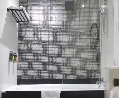 ein Bad mit einer Dusche und einer Glastür in der Unterkunft Tilsitt Etoile Paris in Paris