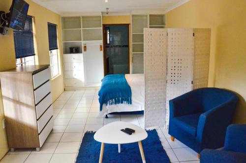 a living room with a bed and a couch and a table at Kleinbosch Lodge in Stellenbosch