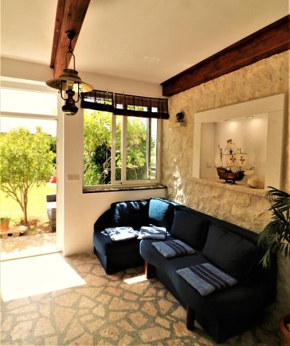 a living room with a black couch and a window at Apartments VESNA in Pag