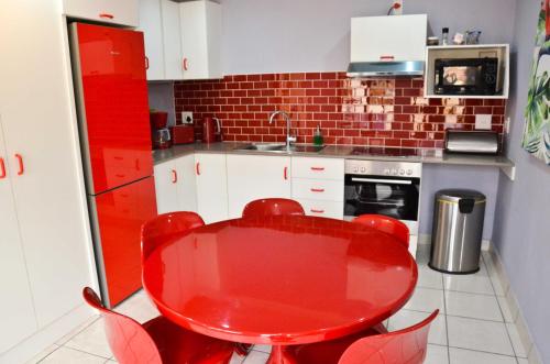 a red table and chairs in a kitchen at Kleinbosch Lodge in Stellenbosch