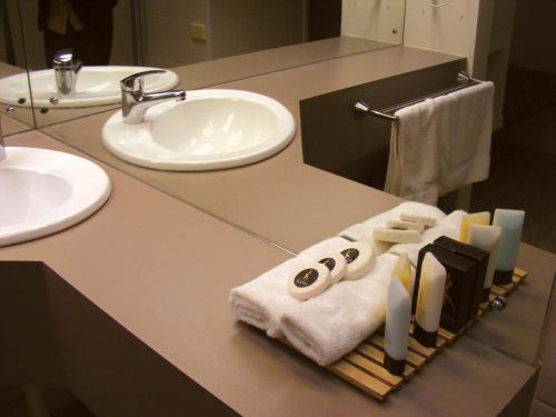 uma casa de banho com um balcão com um lavatório e toalhas em Rich River Golf Club em Moama