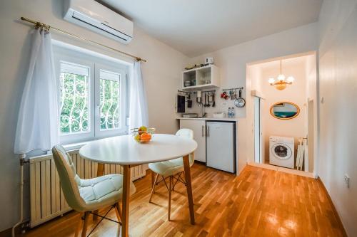 - une cuisine avec une table et des chaises dans la chambre dans l'établissement Kavon Apartments, à Ljubljana