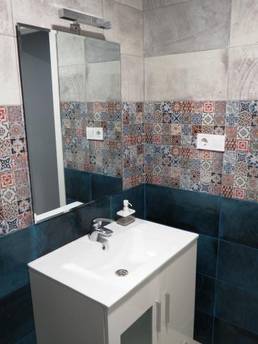 a bathroom with a sink and a mirror at Casa Rural El Setal. in Villasana de Mena