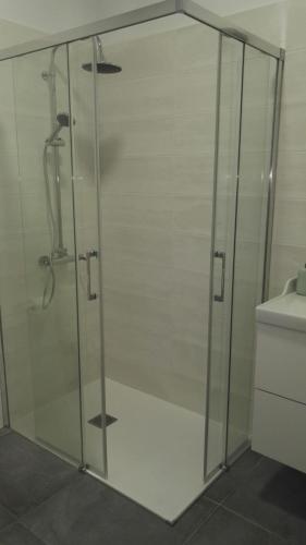 a glass shower in a bathroom with a toilet at Beautiful Apartament Arrieta in Haría
