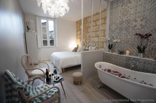 a bathroom with a bed and a tub in a room at La Parenthèse des Capucins - Maison d'hôtes Bordeaux in Bordeaux