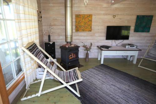 ein Wohnzimmer mit einem Holzofen und einem Schreibtisch in der Unterkunft Viesu mājas Briedīši in Raiskums