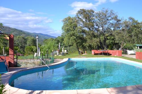 a swimming pool with blue water in a yard at La Granja del Pescador in Casas del Castañar