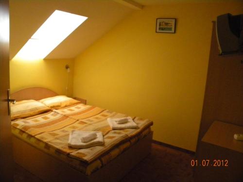 a bedroom with a bed with towels on it at Pensiunea Casa Vulkan in Ocna Sibiului