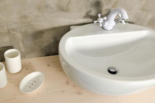 a bathroom with a white sink on a wooden counter at Homutův statek in Kokořín