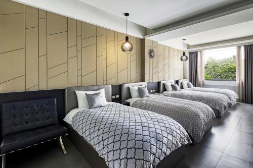 a room with four beds and a black chair at 非住不可 市區民宿附專用停車場 in Hualien City