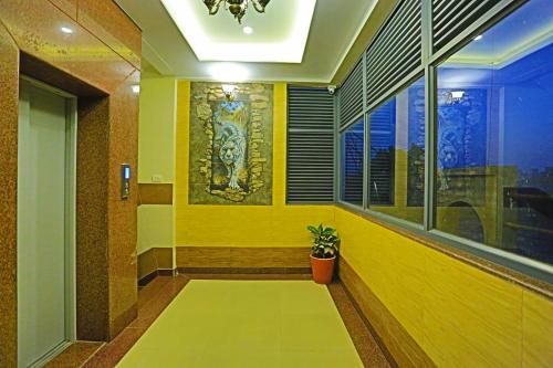 a hallway with a yellow wall and a potted plant at Hotel Suraj Palace in Udaipur