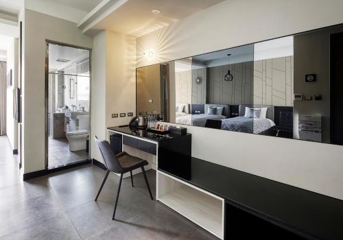 a hotel room with a desk and a bedroom at 非住不可 市區民宿附專用停車場 in Hualien City