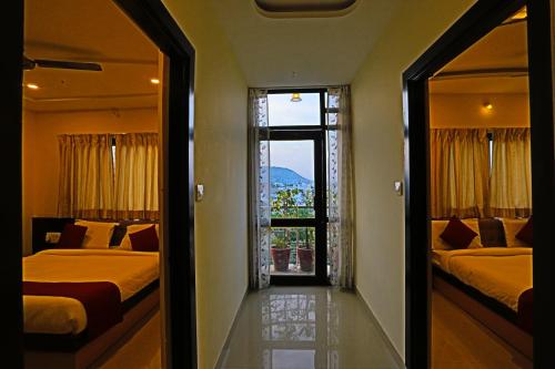 a bedroom with two beds and a view of a window at Hotel Suraj Palace in Udaipur