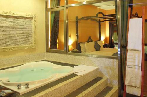Howard Villa في كنتيج: حمام مع حوض استحمام مع مرآة كبيرة