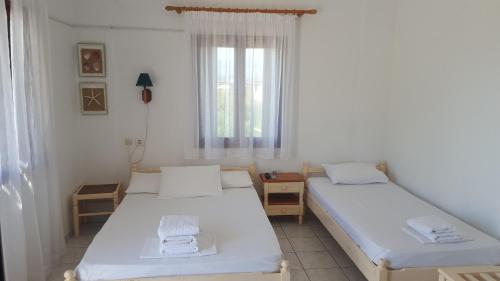 a room with two beds and a window at Aeolos Hotel Apartments in Gythio