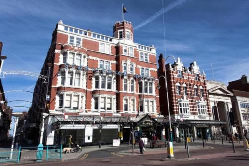 a large red brick building on a city street at Scarisbrick Hotel in Southport