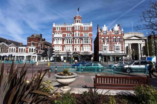 a city street with a bench and a building at Scarisbrick Hotel in Southport