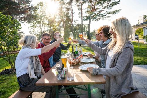 a group of people sitting around a table drinking wine at Terrassenwohnung "Usedom" - Oase am Haff in Garz-Usedom
