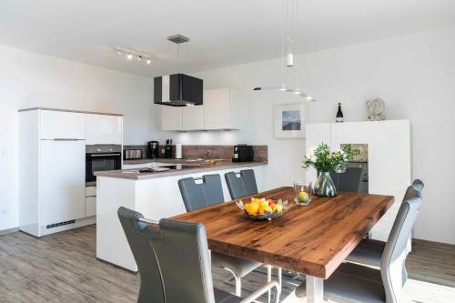 a kitchen and dining room with a wooden table and chairs at Terrassenwohnung "Usedom" - Oase am Haff in Garz-Usedom