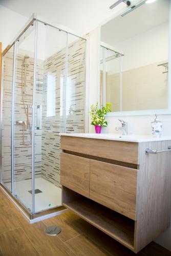 a bathroom with a glass shower and a sink at Casa Mamalola in O Grove