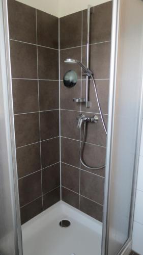 a shower with a shower head in a bathroom at Gästehaus Eisenstrasse in Trofaiach