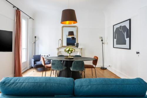 a living room with a blue couch and a table at Appartement Monceau in Paris