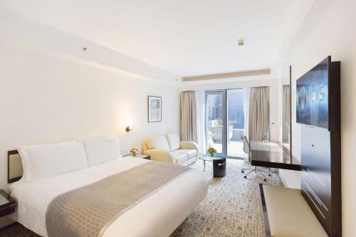 a hotel room with a bed and a flat screen tv at Regal Airport Hotel in Hong Kong