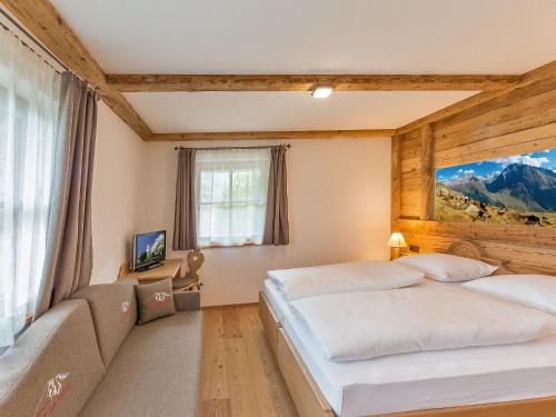 a bedroom with two beds and a couch at Chalet Piz da Peres in Valdaora