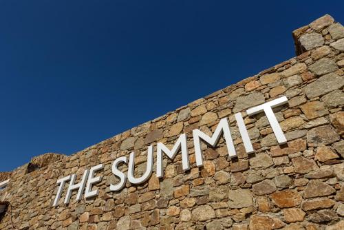 a sign on the side of a brick building at The Summit of Mykonos in Kalo Livadi