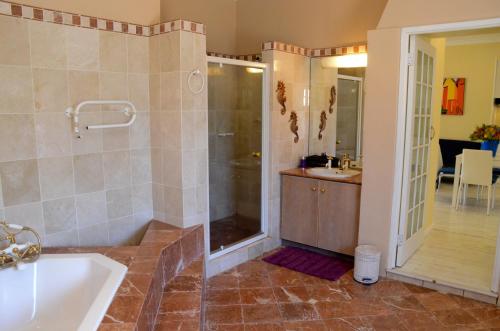 a bathroom with a shower, sink, and tub at Kleinbosch Lodge in Stellenbosch