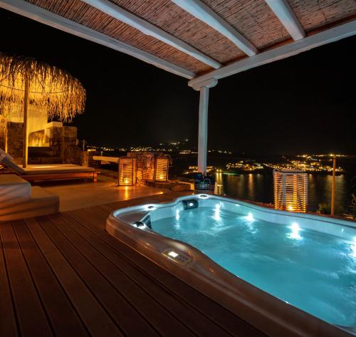a hot tub on the deck of a building at night at The Summit of Mykonos in Kalo Livadi